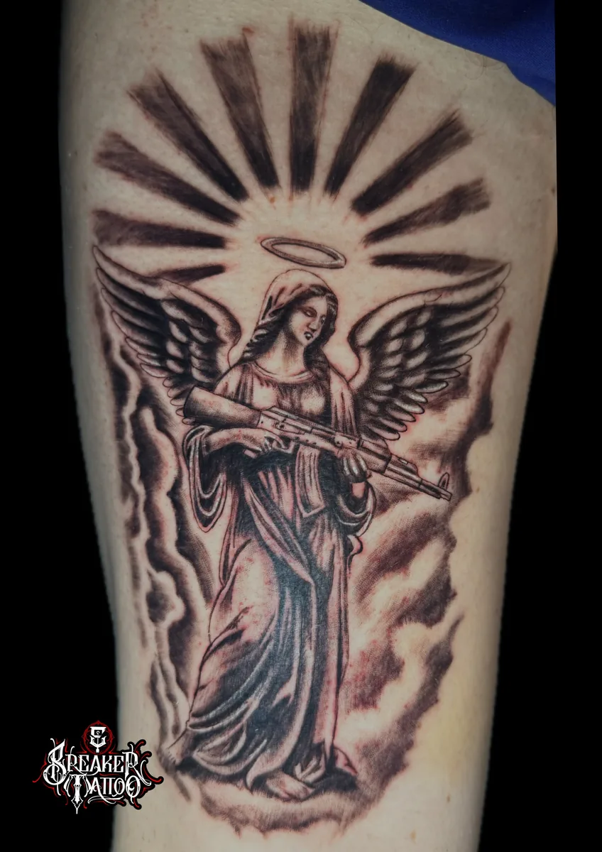 Engelsfigur mit Strahlenkranz auf dem Oberarm in Black and Grey